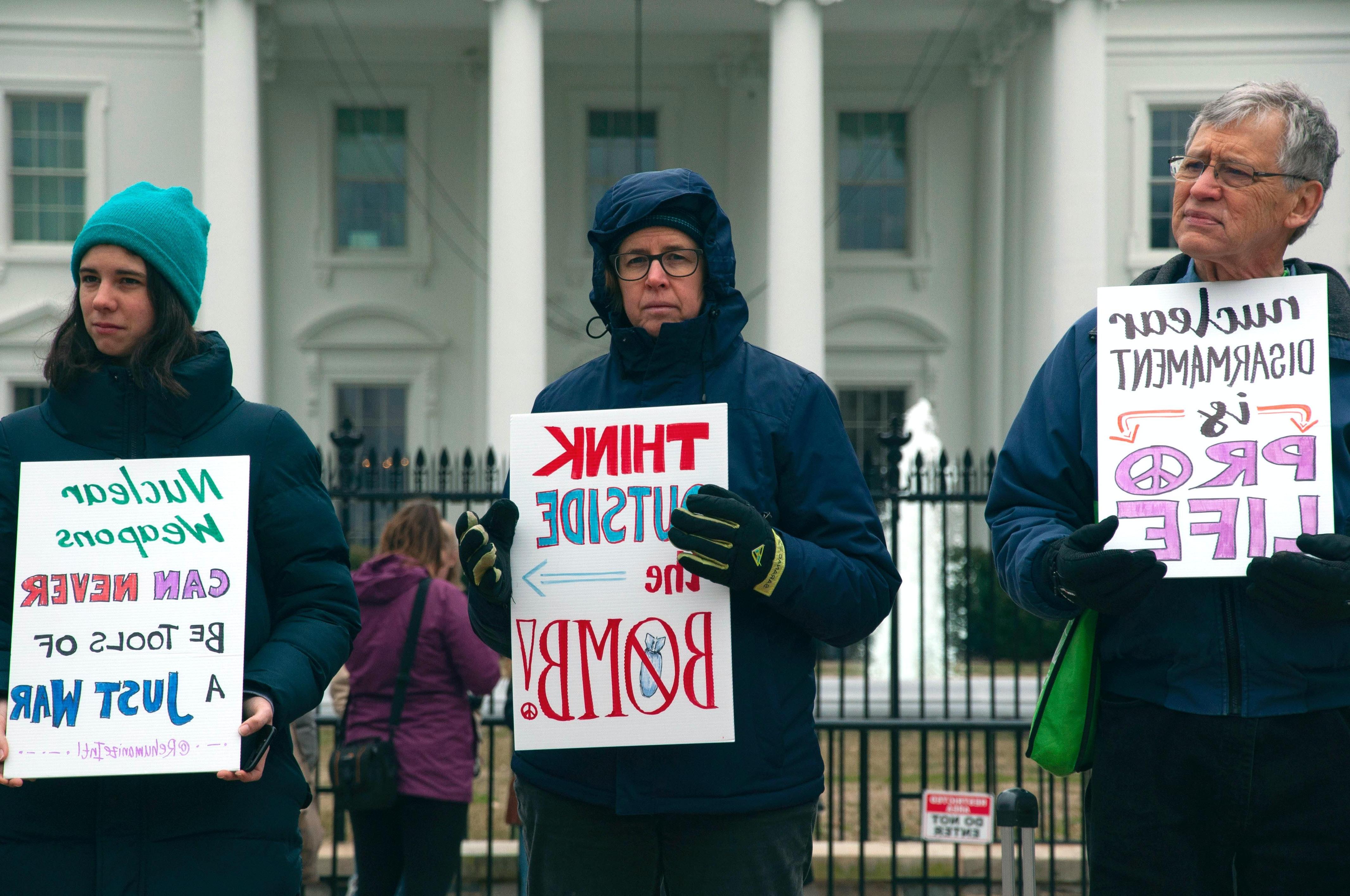一名男子和两名女子在白宫外抗议核武器
