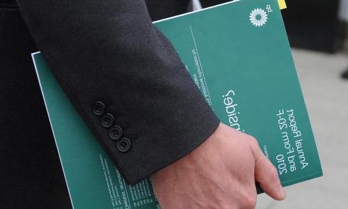 Person holding a BP annual report booklet.