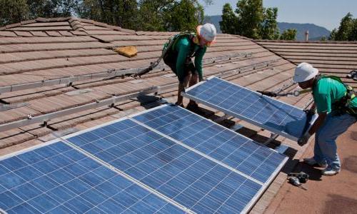 Workers installing rooftop solar panels